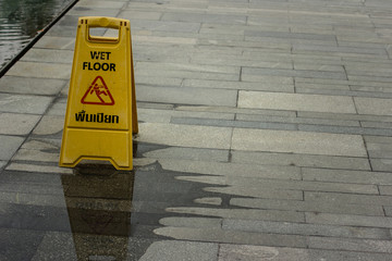 Sign showing warning of caution wet granite floor.