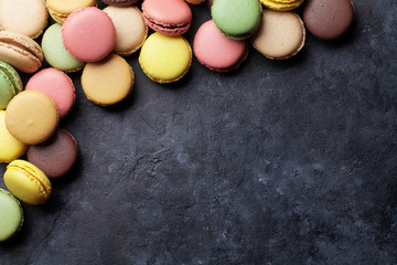Colorful macaroons on stone table. Sweet macarons