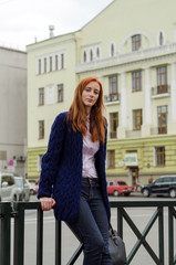 Plakat Young red woman walking in the city