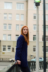 Young red woman walking in the city