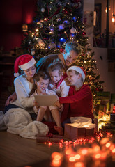 Fototapeta na wymiar At christmas a lovely family find a digital tablet in their gift