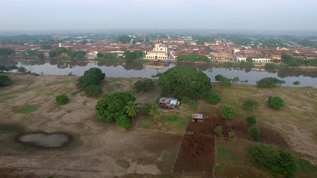 Aerial view of Mompox, Colombia with the camera flying over the Magdalena River towards town
