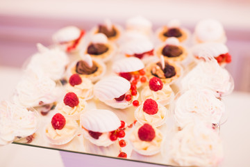 Delicious and tasty dessert table with cupcakes shots at reception closeup