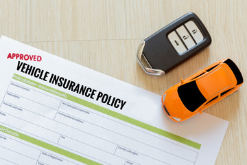 Top view of Approved vehicle insurance policy with car key