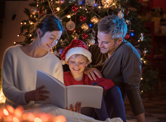 Christmas night. a nice family reading a book together