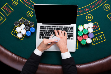 casino, online gambling, technology and people concept - close up of poker player with playing cards