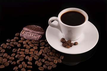 Coffee cup with coffee beans surrounding 