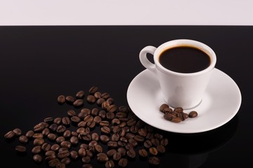 Coffee cup with coffee beans surrounding 