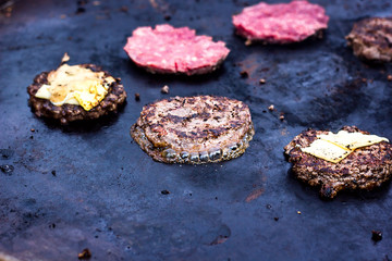 Cooking beef and pork patty with eggs and cheese for burger. Meat roasted on fire barbecue kebabs on the grill. Grilled burger cutlet beef minced meat patties or frikadeller in a pan. Street food. 