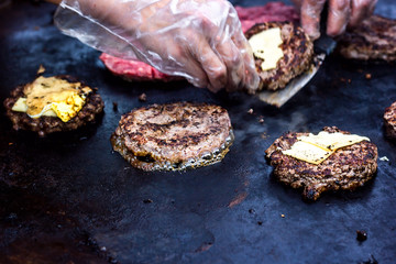 Cooking beef and pork patty with eggs and cheese for burger. Meat roasted on fire barbecue kebabs on the grill. Grilled burger cutlet beef minced meat patties or frikadeller in a pan. Street food. 
