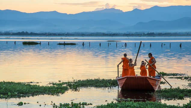 Novice monks row a boat in the lake,Phayao,Thailand