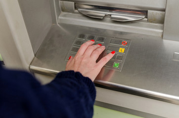 Young red woman using the cash machine