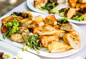 Beautifully decorated catering banquet table with different food snacks and appetizers with sandwich, pancakes, fresh salad on corporate christmas birthday party event or wedding celebration.
