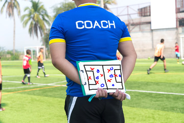 Coach is coaching Children Training In Soccer Team