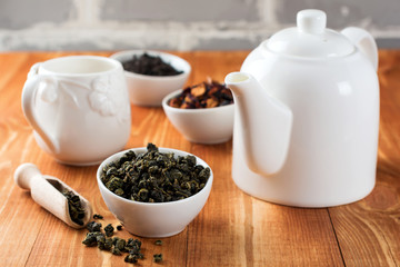 Oolong green tea in white ceramic bowl on a wooden table. Selective focus.