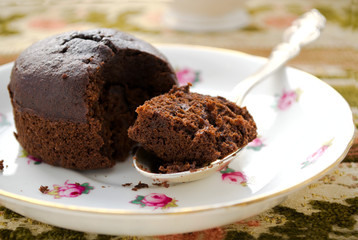 Chocolate fondant, souffle cake with whipped cream on decorative plate