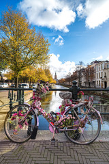 Abandoned decorated and rusty pink bicycle attached to the ramp