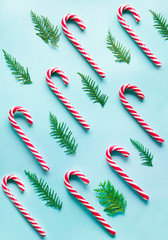Christmas candy cane lied evenly in row on blue background. Flat lay and top view