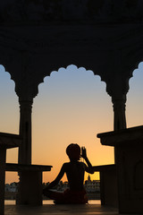 Silhouette of a sadhu performing ritual prayer in the evening at Pushkar Lake. One of the holiest place in India