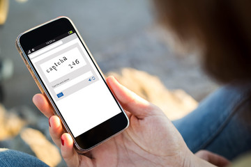 woman sitting in the street holding her smartphone showing captc