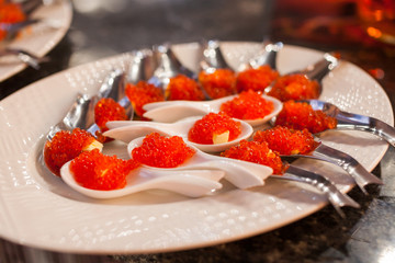 buffet with red caviar, red caviar close-up in white spoons, restaurant, delicacies, snack to beer
