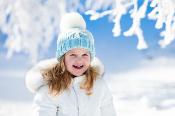 Child having fun in snowy winter park