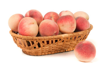 peaches in a wicker basket isolated on white background