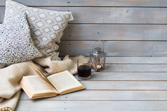 Cushions, plaid, lantern, black coffee and old book on the white