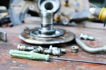 Old, oiled wheel hub lies on a wooden table