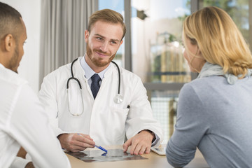 Doctor consulting mutiracial couple in office