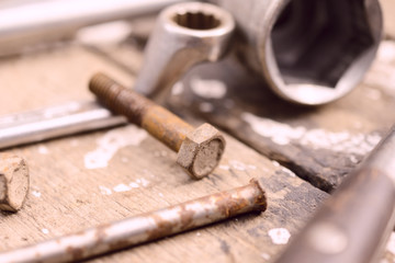 On weathered old wooden surface lie the , oily wrenches.