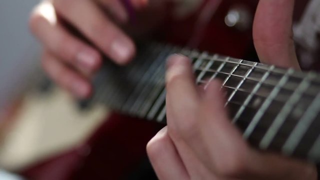 Guitarist hand strumming at electric guitar string