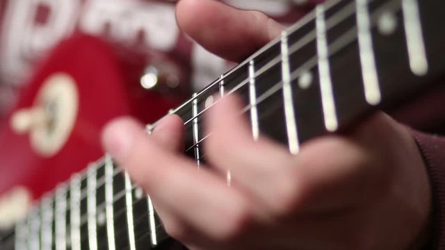 Rock musician with electric guitar fretting chord