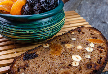 Sliced rye bread with prunes, dried apricots and hazelnut on old rustic table