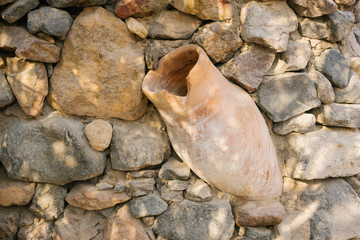 Fototapeta na wymiar An ancient jug on a background of stones