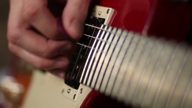 Hands of man playing electric guitar