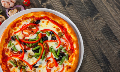 vegetarian pizza with vegetables on a wooden table