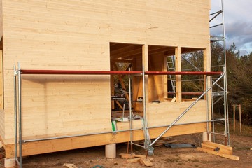 Construction of ecological house. External work on the building envelope. The wooden structure of the house near the forest.
