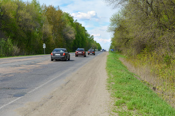 cars on the road in a wooded area