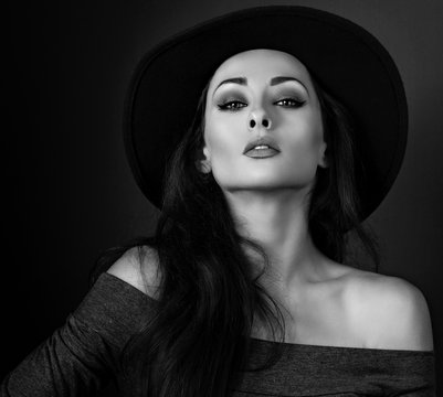 Expressive makeup woman in fashion elegant hat posing on dark sh