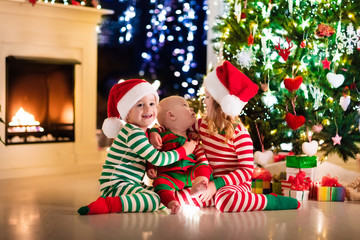 Fototapeta na wymiar Kids in pajamas under Christmas tree