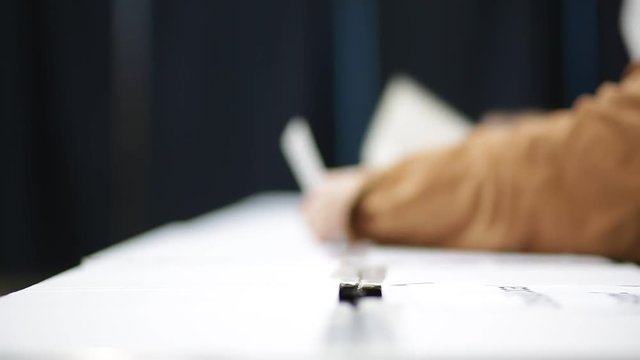 Unrecognizable people cast their vote during elections in a voting station