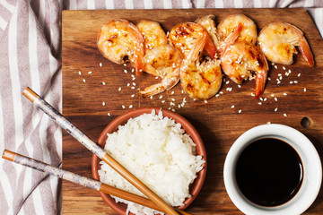 Rice with shrimp and soy sauce on a black background, horizontal, soft focus
