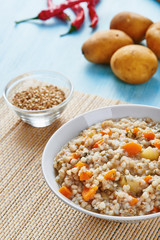 Buckwheat soup in white bowl on wooden blue table