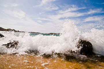 Obraz premium Wave breaking on the sea shore in Sardegna, Italy