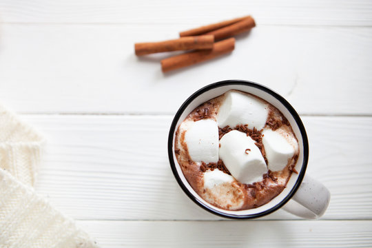 Hot chocolate with marshmallows in a ceramic cup, plaid and cinn
