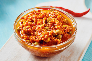 Bolognese sauce in glass bowl on cutting board