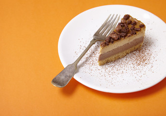 A slice of toffee cheesecake dessert on a bright orange background forming a page border