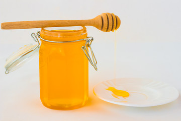Jar with honey on a white background. Нoney dipper on  jar