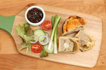 Pork pie and salad on chopping boards
